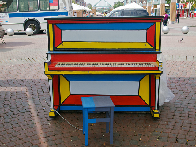 I will say, though, that it was one of the more colorfully painted pianos of all the ones I've seen... ********************************** On the 5th day of the "Play Me, I'm Yours" project, my main objective was to photograph all of the pianos in the Bronx -- though I also intended to get the piano at the Cathedral of St. John the Divine, which I had somehow overlooked in northern Manhattan... I started at 149th and the Grand Concourse, where a lonely piano sat out on the street, in front of the Eugenio Maria de Hostos Community College; and from there I went up to 161st Street and the Grand Concourse, to track down a lonely piano sitting in a corner of Joyce Kilmer Park. (For all of you baseball fans, the park is located just a couple blocks due east of the new Yankee Stadium.) From there, I traveled further north into the Bronx, to find the piano at Fordham University. Contrary to what the piano-website's map had indicated, the piano was not located on the main campus (where I searched high and low, and listened to several guards and admin people tell me they had never heard of such a thing), but instead across the street in the entrance to a local railroad stop. From there, I went to my northernmost stop in the Bronx, at the corner of Van Cortlandt Park, on Jerome Ave & E. Gun Hill Road. For some reason, the piano was placed in the passageway of the outdoor restroom facility of the park ... at least it had the advantage of not being rained on in bad weather. When that was finished, I took a cab back down to Manhattan, and tracked down the final piano of the day -- in the outdoor garden of St. John the Divine. Like all the others I saw today, this one was also unoccupied ... but at least it was in a lovely setting, so I got a few nice pictures before calling it a day... ***************************************** A few years ago, a British artist by the name of Luke Jerram came up with the intriguing idea of spreading pianos around the city, with an open invitation for anyone nearby to wander up and begin playing something. Anything. First it was London, and now it's here in New York City. Starting on June 21st, sixty pianos have been donated, painted, and "installed" throughout the five boroughs of New York; you can see the locations here. I managed to visit seven of the pianos on the first day, and another seven on the second day. The program will only be running for two weeks, and I'll be out of town for at least a few of those days ... so it won't be easy, but my goal is to track down, visit, and photograph all 60 pianos by the time it's over. Even the one at the Staten Island Zoo, and the one located somewhere in the Joyce Kilmer Park up in the Bronx. Aside from the logistics of getting to these remote corners of the five boroughs, it sounds like a straightforward task: ride a subway train to the appropriate stop, walk a block or two, take photograph or two, and then go back where you came from. But it's turning out to be a little more difficult than I had thought, partly because the maps provided on the Web site are somewhat ambiguous and imprecise, and partly because the officials (e.g., guards, cops, grounds-keepers, etc.) whom you would expect to know about such things have been remarkably clueless. I've also been hearing rumors that some of the pianos are being moved around between one day and the next. That might explain why I had to abandon today's plan to photograph the piano in Bryant Park: after circling the park and the adjoining New York Public Library a couple of times, I concluded they had either hidden the piano, or moved into a subterranean cell. As for the pianos I've found, the experiences have been quite varied. Some of the pianos sit mute and abandoned -- including, oddly enough, the very fist piano in Times Square, which had been plunked down at Seventh Avenue and 44th Street, and basically ignored by everyone. The same was true of one of the pianos situated in a hard-to-find corner of Lincoln Center, as well as a piano ostensibly located at the Metropolitan Museum of Art -- which turned out to be sitting next to the giant obelisk behind the museum, and on the far side of the inner park roadway. As for the pianos that do attract some musicians: it's quite a varied bunch. Some are casual amateurs, some of whom have no idea what the program is all about, and who had no advance warning that the pianos would even be there. Some have obviously been planning and practicing for months. Some of the musicians sing, some don't; some bring along drummers, guitarists, and vocalists. I even heard that one musician brought some dancers to help liven up his performance, but I haven't seen that myself... Anyway, I'll keep photographing the pianos, and uploading the best of the photographs, until I run out of pianos, run out of time, or run out of energy -- whichever happens first.